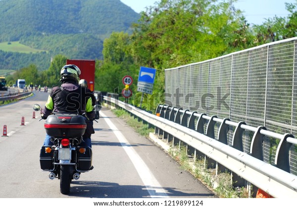 bikers on\
motorcycles and protective suits riding on the track with road\
markings, the theme of transport and\
travel