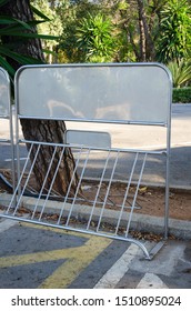 A Bikes Stand Made Of Stainless Steel For Parking In A Public Parking Spot. Sportsmen And Active People Also Need Their Own Parking Spot. In The Background You Can See Trees And A Parking Spot Fo