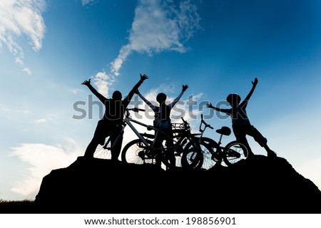 Biking family at sunset sky background. Active healthy outdoor lifestyle concept