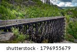 Biking over one of the 18 Wooden Trestle Bridges of the abandoned Kettle Valley Railway in Myra Canyon near Kelowna, British Columbia, Canada