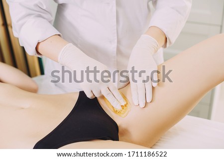 Bikini depilation waxing. The master makes hair removal in the salon
