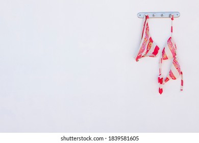 Bikini drying on wall hook on a bright background. - Powered by Shutterstock