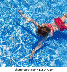 bikini kid girl swimming on blue tiles pool in summer vacation
