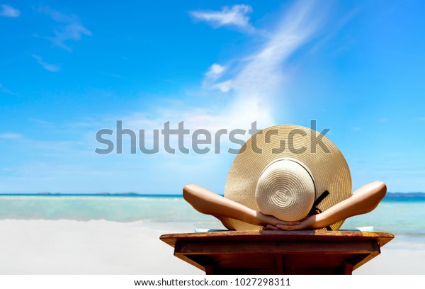 Bikini woman sexy in\
relax beach and resting resort in vacation on summer season with\
sunhat sitting chair sunbath with swimsuit alone at island\
lifestyle on weekend\
holidays