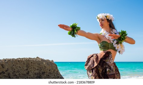 Bikini woman at the sunset in summer. Hula dancer performing hawaii dance. Girl dancing wearing tahiti summer clothes. Miss queen flower crown at the sea looking at the waves.