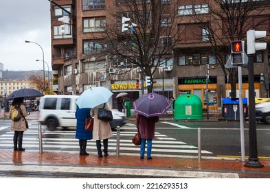 Bilbao, Basque Country, Spain - January 25, 2019: People Are Waiting At The Crossroads On A Rainy City Street. Wet Weather