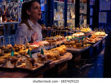Bilbao, Biscay/Spain; October 20 2020: Bar full of basque food. Bartender serving food. Interior.