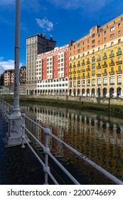 BILBAO, SPAIN - FEBRUARY 14, 2022: Ribera Del Nervión Area With The Bailen Skyscraper And The Railway Station Reflected On The Water In The City Of Bilbao , Basque Country, Spain.