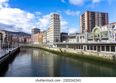 BILBAO, SPAIN - FEBRUARY 14, 2022: Ribera Del Nervión Area With The Bailen Skyscraper And The La Concordia Railway Station Reflected On The Water In The City Of Bilbao , Basque Country, Spain.