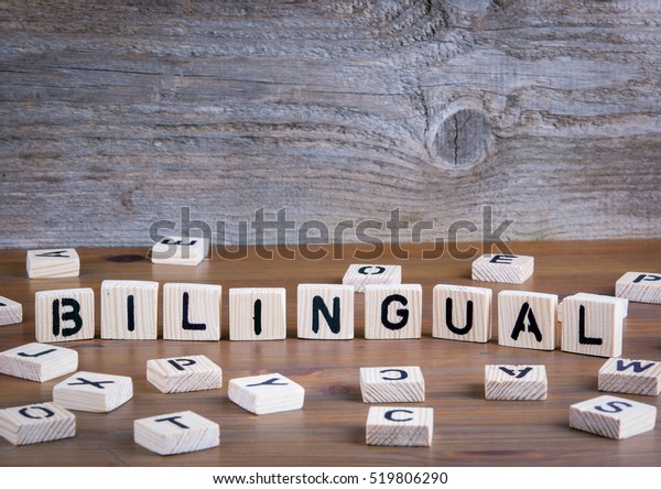 Bilingual from\
wooden letters on wooden\
background