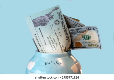 A Bill Jar Holds Money And A Economic Impact Payment, Pr Stimulus Check, Help For The American People Struggling Through Covid 19