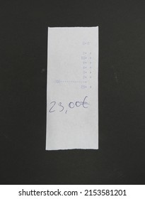 Bill Or Receipt Over A Black Background, With Handwritten Sum (aka Total)