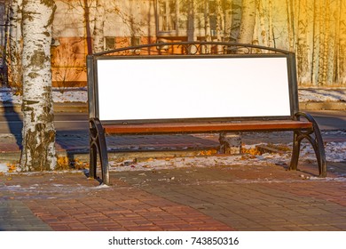 Billboard with blank white copy space for text message or content, mock up banner on a city bench, illuminated by sunlight