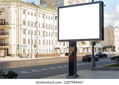 Billboard in the city in the summer near the road against the backdrop of a light building. Mock-up.