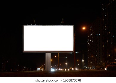 Billboard Near The Road In The Night City. With A White Field For Advertising