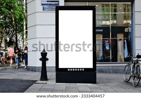 billboard at street corner. blank poster and advertising ad space. digital outdoor lightbox. base for mockup. empty display panel. glass design. soft streetscape. urban background with blurred people