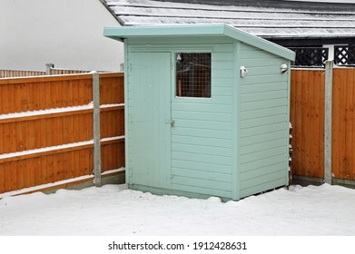 Billericay, Essex, United Kingdom, February 8, 2021. Back Garden Pentland Wooden Shed, Cabin, Hut Or Man Cave. Painted Green. Snowy Winters Day. Billericay, Essex, United Kingdom, February 8, 2021