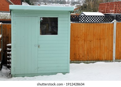 Billericay, Essex, United Kingdom, February 8, 2021. Back Garden Pentland Wooden Shed, Cabin, Hut Or Man Cave. Painted Green. Snowy Winters Day. Billericay, Essex, United Kingdom, February 8, 2021