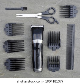 Billericay, Essex, United Kingdom, January 28, 2021. Hair Clippers, Trimmers, Buzz Cut Scissors And Combs. On A Grey Stone Slate Background. Billericay, Essex, United Kingdom, January 28, 2021.