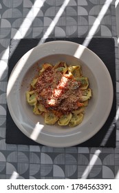 Billericay, Essex, United Kingdom, May 20, 2020. Bowl Of Pasta In Tomatoe Sauce Sprinkled With Parmesan Cheese. Sun Dappled Top Down View. Billericay, Essex, United Kingdom, May 20, 2020