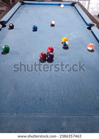 Billiard balls are arranged randomly on a blue table