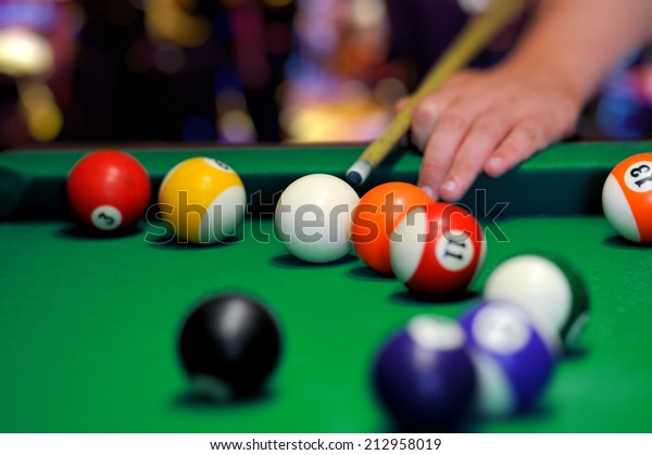 Billiard balls in a green\
pool table