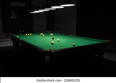 Billiard Balls Scattered On Pool Table In Empty Dimly Lit Pool Hall