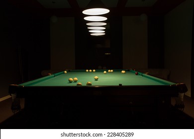 Billiard Balls Scattered On Pool Table In Empty Dimly Lit Pool Hall