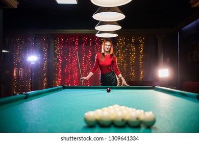 Billiard club. A woman with red hair standing by the table