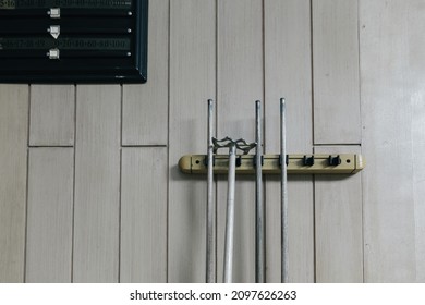 billiard cue sticks, Cue snooker hang on white wall, Billiard cues on the rack, Wooden cues for table game