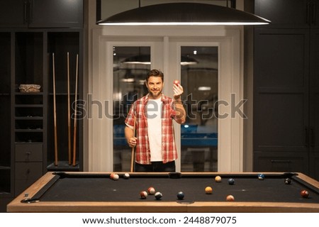 The billiard. Guy Playing billiards. Man hit ball in billiard in Billiard room. Russian pool billiards. Snooker Player. Young professional man playing billiards in the dark billiard club.