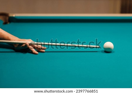 Billiard player calculates the trajectory pathway at billard table or american billiards pool sport game