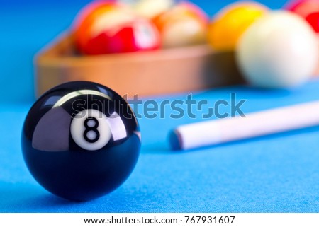 Billiard pool game eight ball with cue and eightball balls set up on billiard table with blue cloth