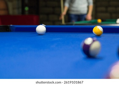 Billiard pool game in progress, balls are on blue table cloth