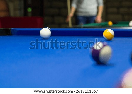 Billiard pool game in progress, balls are on blue table cloth