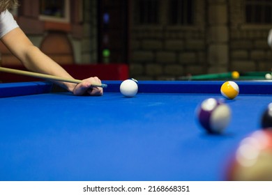 Billiard pool game in progress, player aims to shoot balls with cue - Shutterstock ID 2168668351