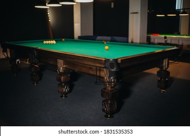Billiard table with green surface and balls in the billiard club.