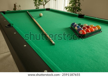 Billiard table setup with cue and racked balls
