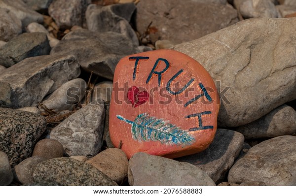 Billings, Ontario, Canada - August 3, 2021:\
orange painted rock along the Kagawong River trail to Bridal Veil\
Falls on Manitoulin\
Island.