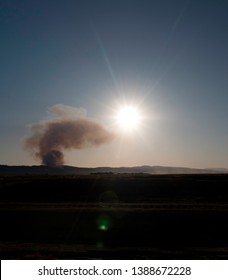 Billowing Smoke Cloud From A Brush Fire At Sunset