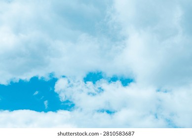 Billowy clouds float effortlessly in a bright blue expanse, creating a serene atmosphere perfect for daydreaming and reflection. Nature's canvas stretches endlessly above.