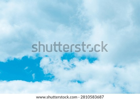 Billowy clouds float effortlessly in a bright blue expanse, creating a serene atmosphere perfect for daydreaming and reflection. Nature's canvas stretches endlessly above.