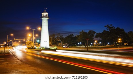 Biloxi lighthouse as night falls with passing automobile traffic in Mississippi