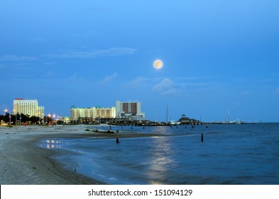 Biloxi, Mississippi, casinos and buildings along Gulf Coast shore in night time image with rising moon