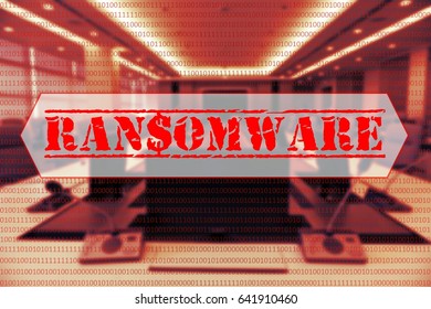 Binary code with the word 'RANSOMWARE' in the center with a blurred background of computer labs.