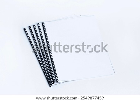 Binded documents with plastic spiral on white background.