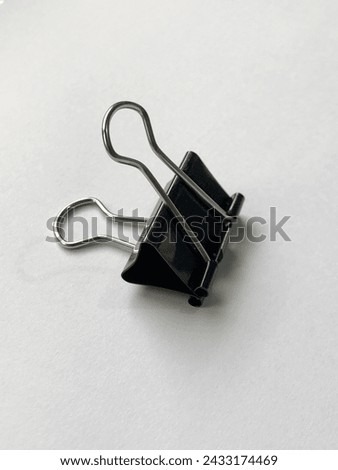 A binder clip is a simple device for binding sheets of paper together.