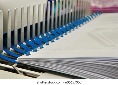 Binding documents with plastic ring binder by using ring binding machine for report preparation.