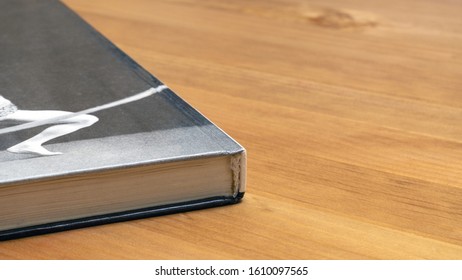 the binding of an old book lying on a wooden table.