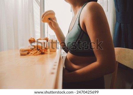 Binge eating disorder concept with woman eating fast food burger, fired chicken , donuts and desserts